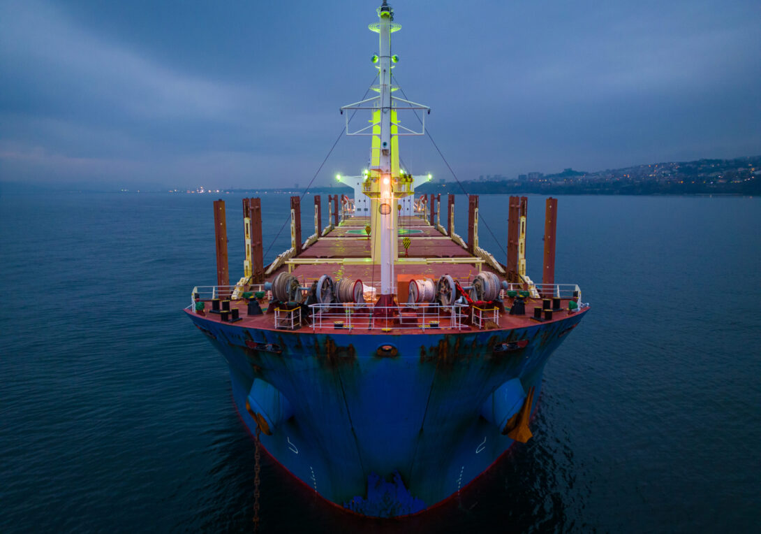 Aerial top view cargo bulk carrier ship on the sea at night